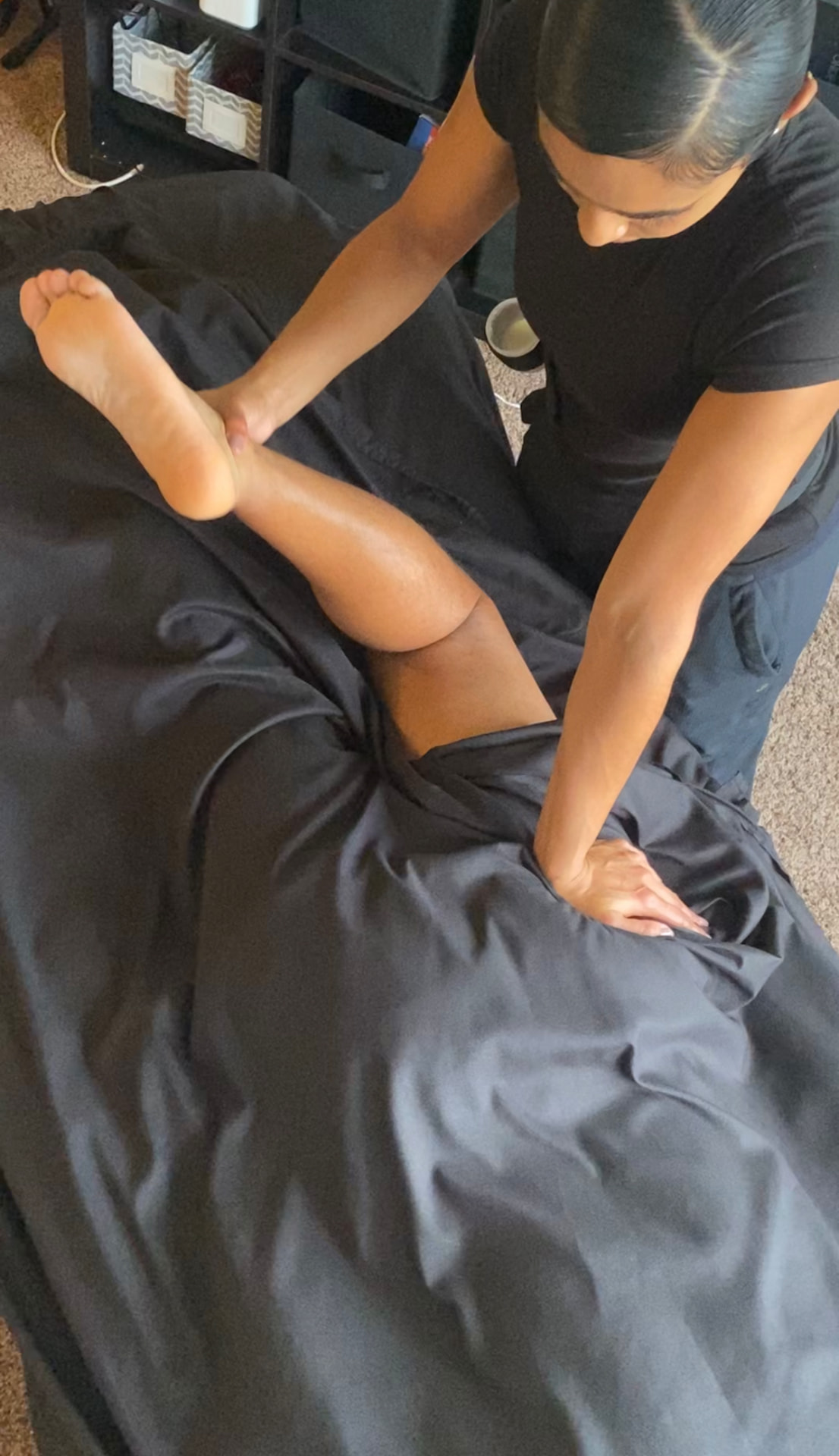 Therapist working along a client's calf and lower back